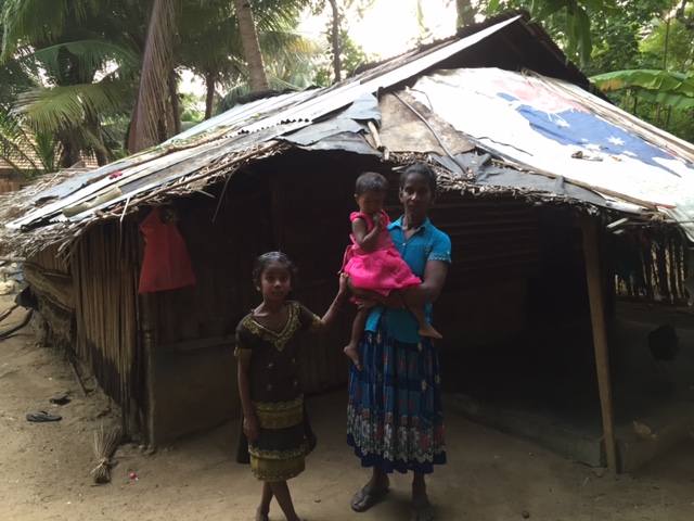 Kavipriya with her family outside their home in Jaffna